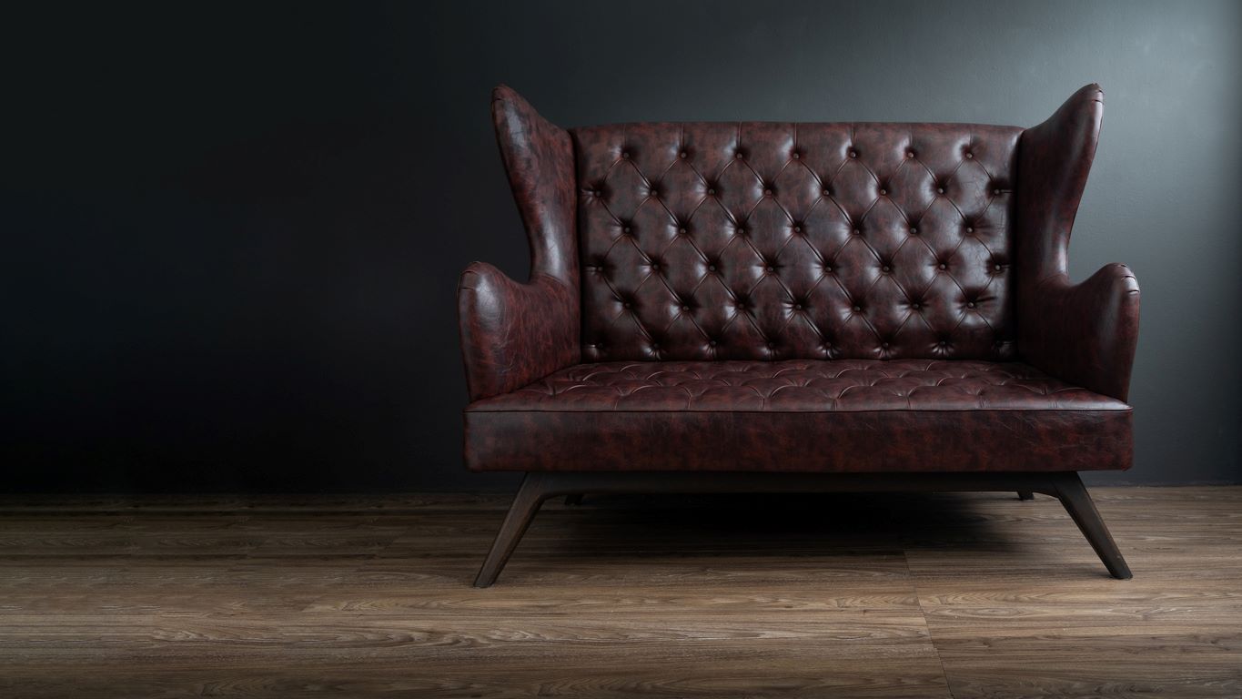 Dark brown leather chair against a black background. 